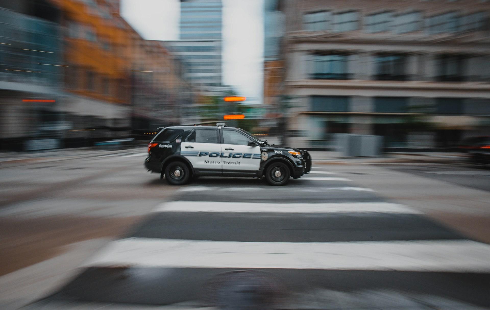 a police car speeding across a city street