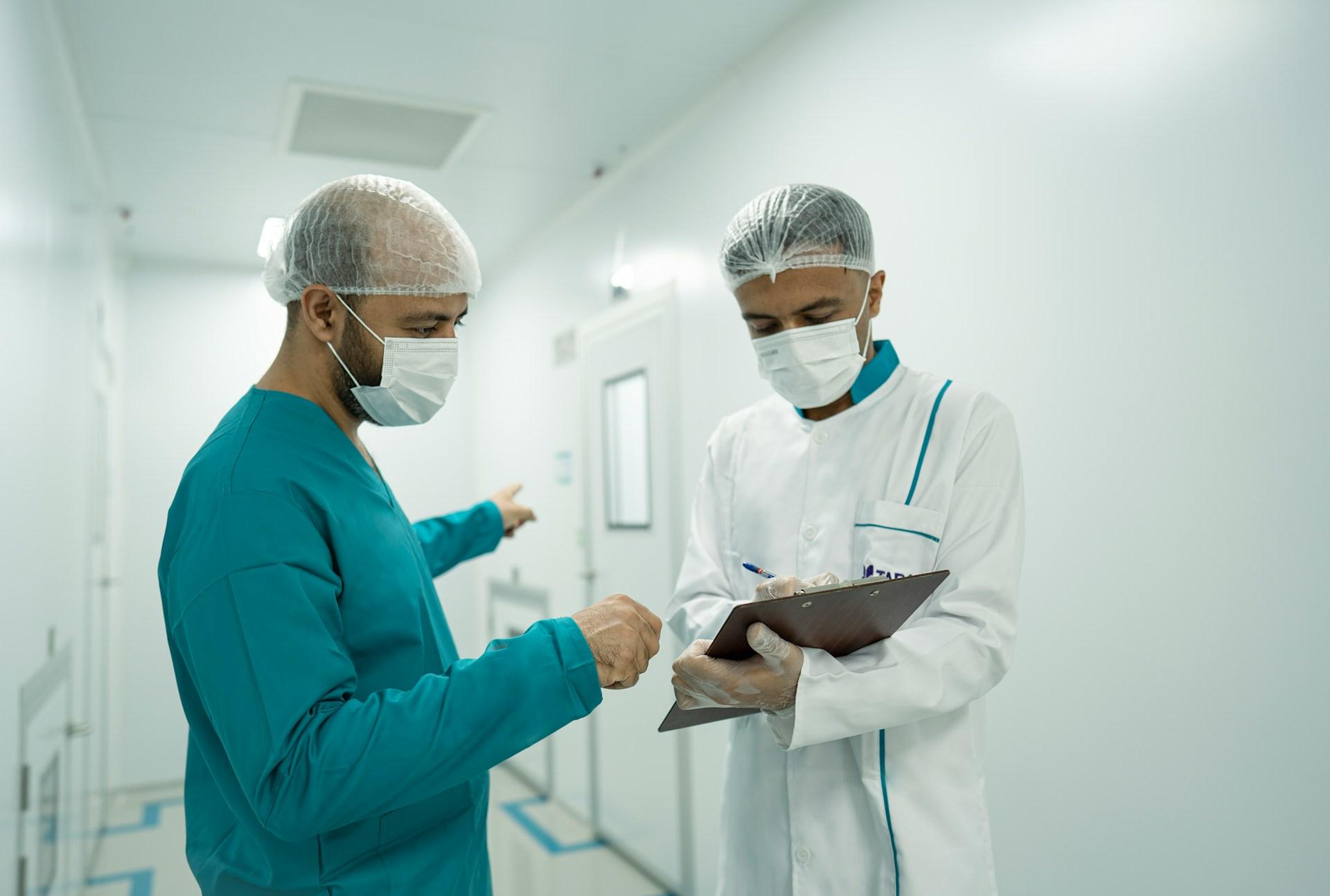 two doctors wearing ppe looking at a clipboard