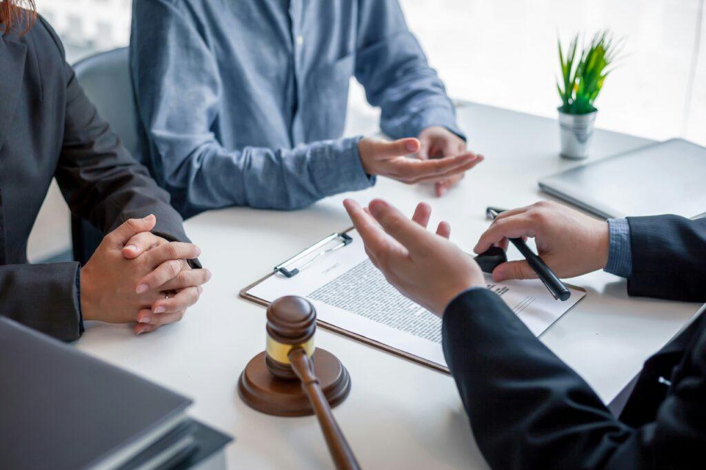 Lawyer meeting with clients in an office, discussing legal documents and providing guidance during a wrongful death case consultation.