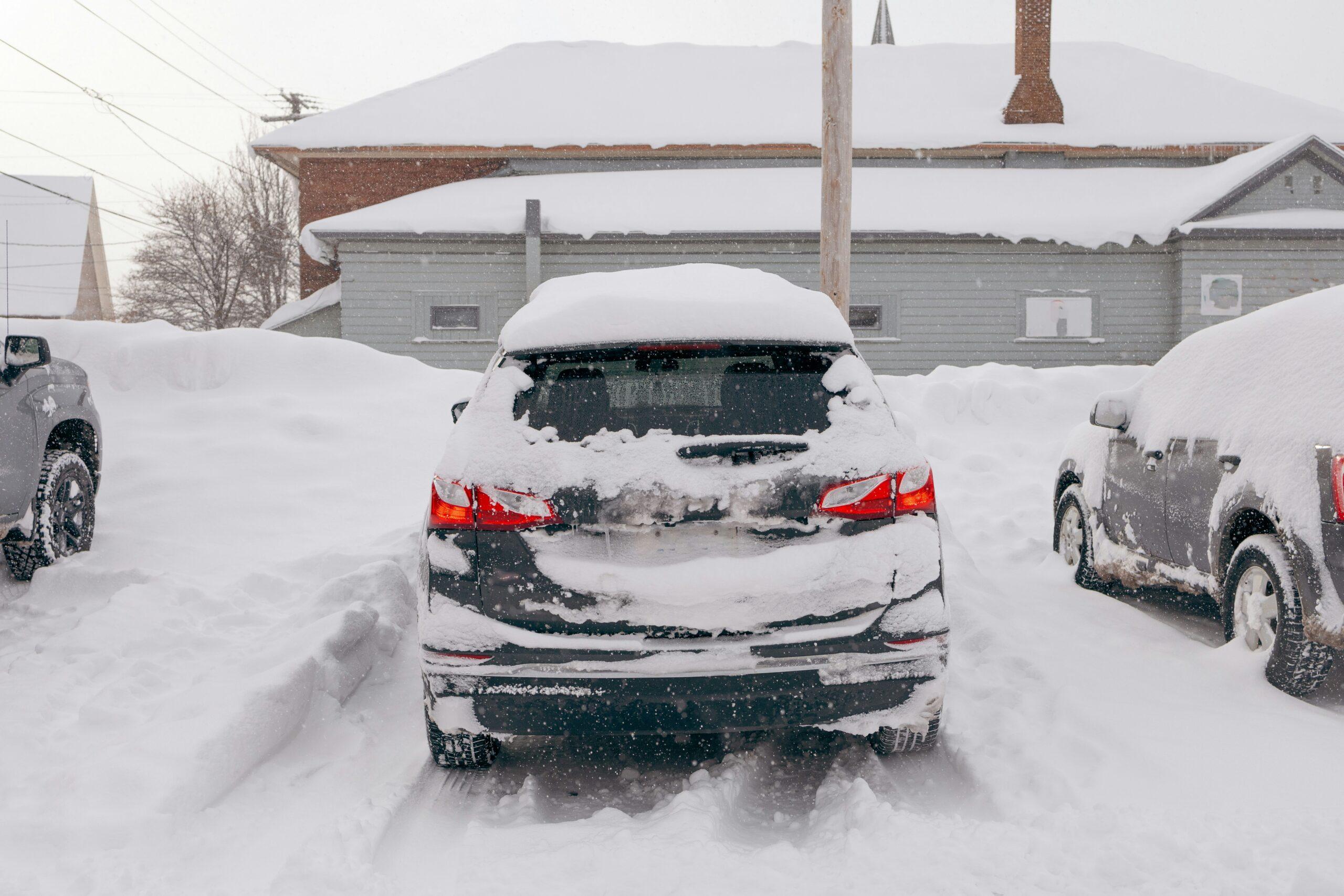 A car parked on a snowy surface, surrounded by a winter landscape.
