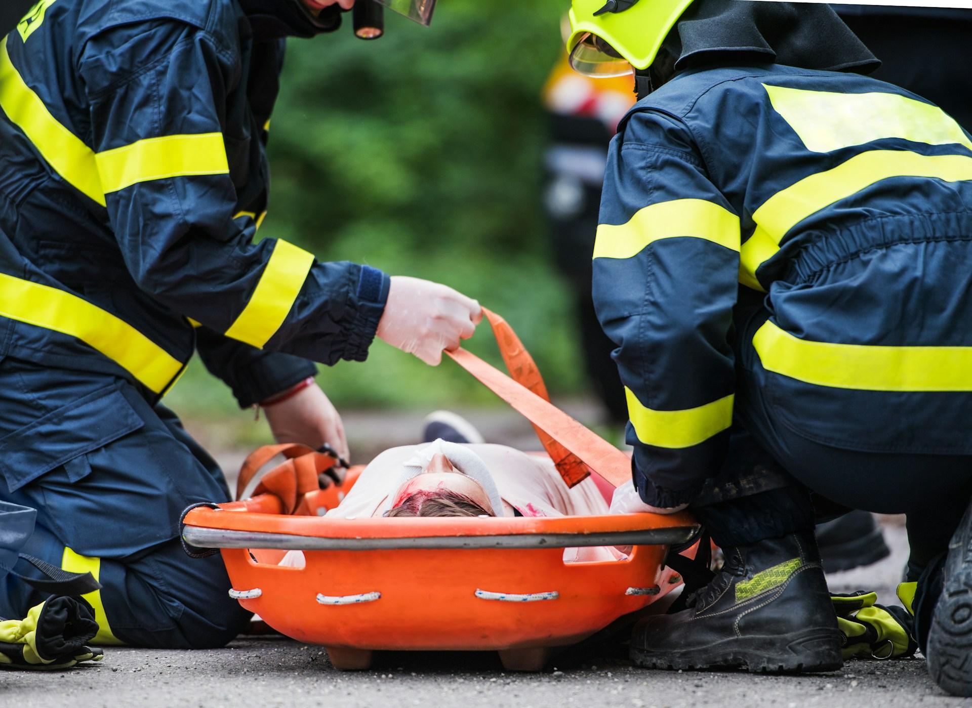 Emergency services personnel treating a patient in an ambulance after a public transport injury.