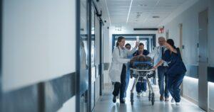 A group of doctors in white coats walking together down a hospital hallway.