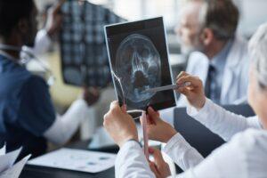 A group of doctors examining an X-ray image together, discussing findings and treatment options.
