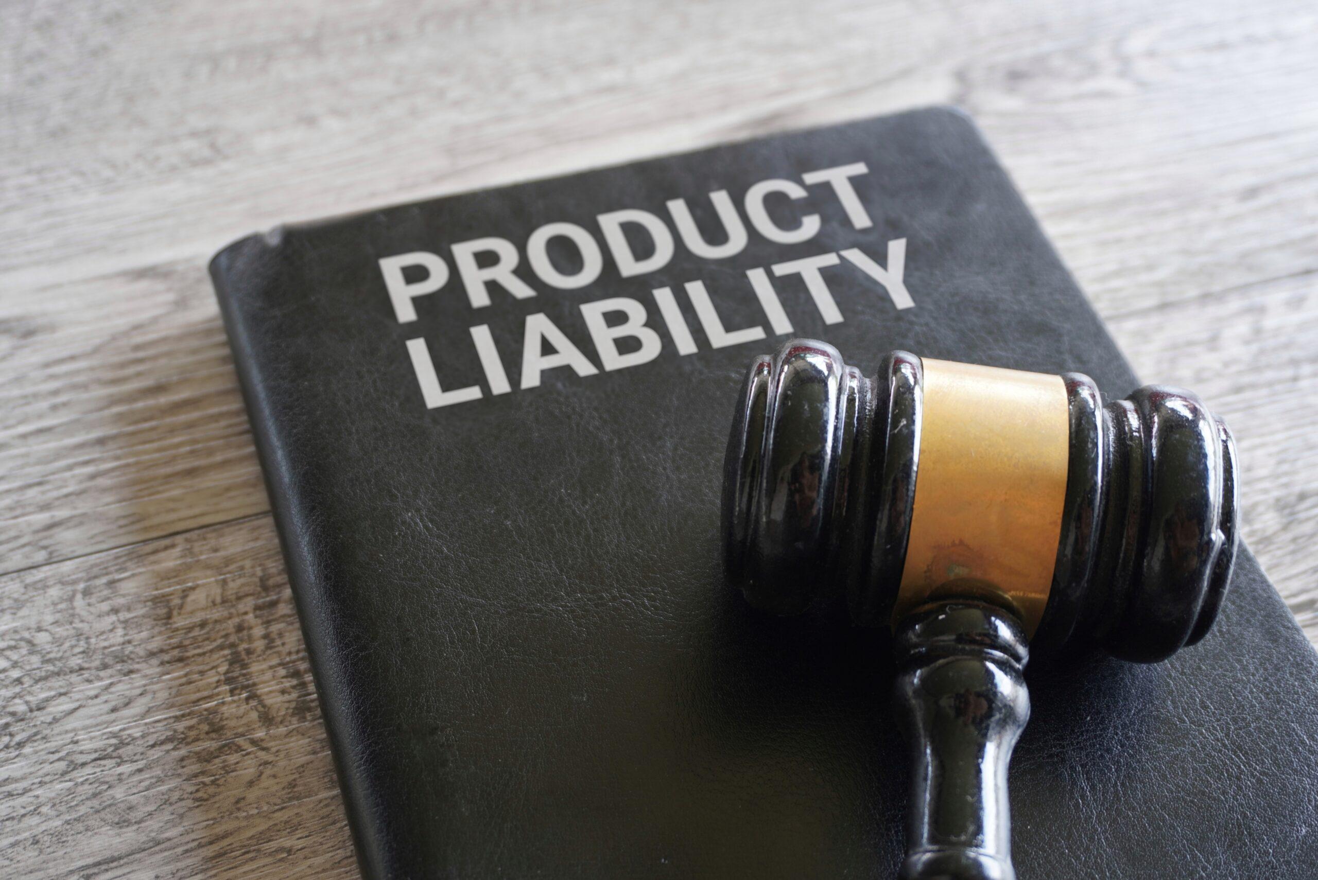 A gavel rests on a black book titled "Product Liability" on a wooden table.