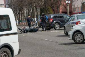 A police officer and rider stand near an overturned motorcycle at a Chicago intersection after a collision with an SUV.